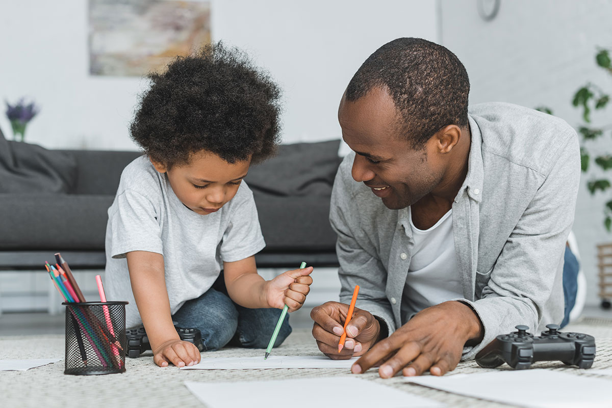 Father and son drawing on the floor